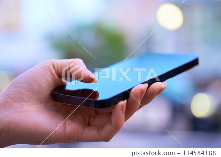 在市中心操作智慧型手機的女性的手 在市中心操作智慧型手機的女性的手 114584188