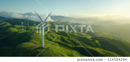 Wind turbines against the backdrop of green hills or fields. 114584294