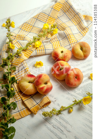 Several whole saturn peaches or flat peach on white wooden background.. Several whole saturn peaches or flat peach on white wooden background.. 114585388
