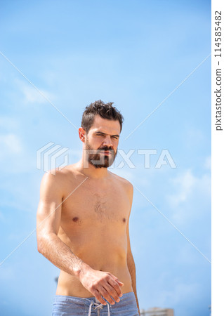 Young adult man with headache or sunstroke walking on the beach 114585482