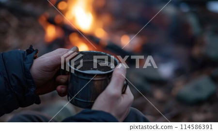 The close up picture of person holding cup of hot coffee near fireplace. AIG43. The close up picture of person holding cup of hot coffee near fireplace. AIG43. 114586391