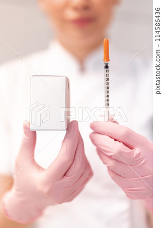 Cosmetologist showing skin lifting injection and 114586436