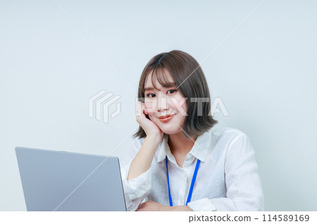 A smiling young woman resting her chin on her right hand A smiling young woman resting her chin on her right hand 114589169