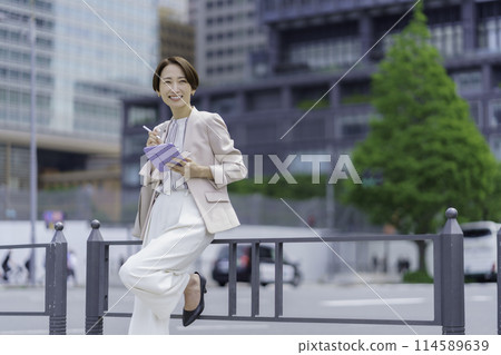 A businesswoman in an office district holding a pen tablet A businesswoman in an office district holding a pen tablet 114589639