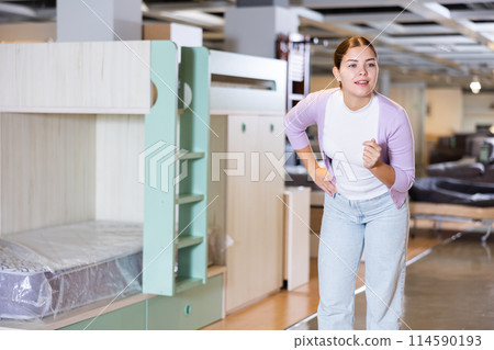 girl is in furniture store and imagines how the new furniture will look in her house 114590193
