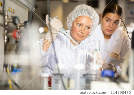 Confident women technicians working in research laboratory 114590470