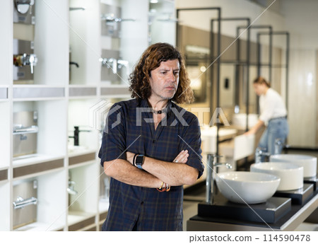 in plumbing department, man thought about choosing suitable bathroom for new apartment in plumbing department, man thought about choosing suitable bathroom for new apartment 114590478