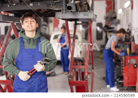Young guy mechanic posing with wrench Young guy mechanic posing with wrench 114590599