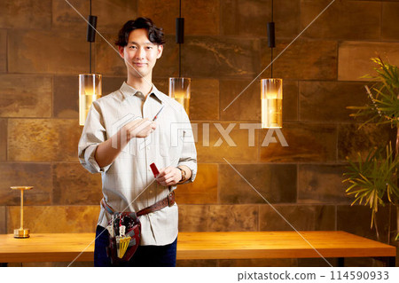 一位年輕的男理髮師微笑著看著你 114590933
