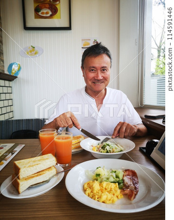 一個男人在家庭餐廳吃早餐吐司 114591446
