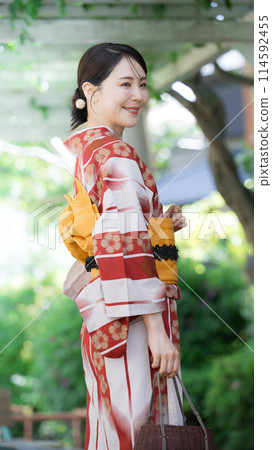 A woman wearing a yukata outdoors in the greenery, a beautiful woman looking back, vertical A woman wearing a yukata outdoors in the greenery, a beautiful woman looking back, vertical 114592455