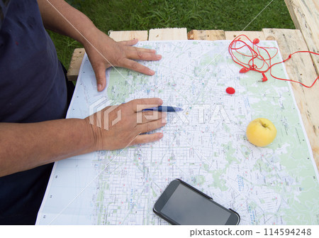 Senior woman looking at a map of Barcelona preparing for a trip, tourism in Europe. Senior woman looking at a map of Barcelona preparing for a trip, tourism in Europe. 114594248