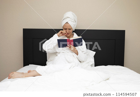 Woman In Her 30s Sits In Bed And Crying Reading A Book. Emotional Empathy Expression Of Face. Sensitive Caucasian Mature Female Reading Romance, Novel Love Sad Story. Book Lover, Horizontal Plane 114594507