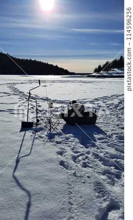 Winter fishing, catching a fish in the North of Sweden Winter fishing, catching a fish in the North of Sweden 114596256