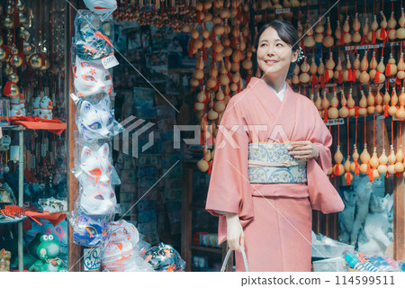 一個穿著和服的女人在旅遊景點購物 114599511