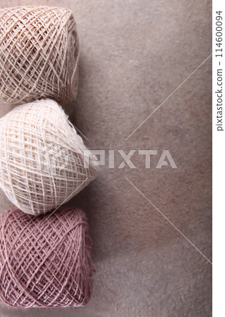 A set of colored cotton yarn for hand knitting. Multicolored balls of yarn for knitting. Handmade work. The concept of a hobby. Skeins of yarn for knitting as a background. Copy space. Vertical photo. 114600094