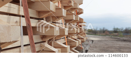 Safe transportation of construction materials. The lumber is loaded into a truck. The boards are stacked for transportation. A narrow banner. Safe transportation of construction materials. The lumber is loaded into a truck. The boards are stacked for transportation. A narrow banner. 114600133
