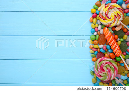 Colorful lollipops and different colored round candy on blue background Colorful lollipops and different colored round candy on blue background 114600708
