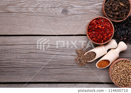 Spices mix on wooden spoons on a grey wooden background. Top view Spices mix on wooden spoons on a grey wooden background. Top view 114600710