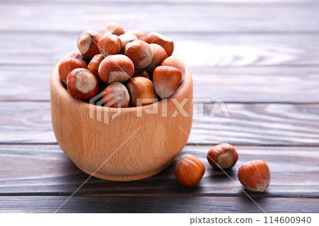 Delicious hazelnut in the wooden bowl on brown background Delicious hazelnut in the wooden bowl on brown background 114600940