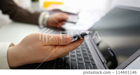 Male arms hold credit card press buttons making transfer 114601146