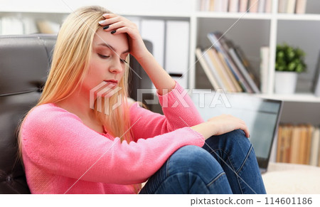 Unhappy lonely depressed woman sitting on the couch Unhappy lonely depressed woman sitting on the couch 114601186