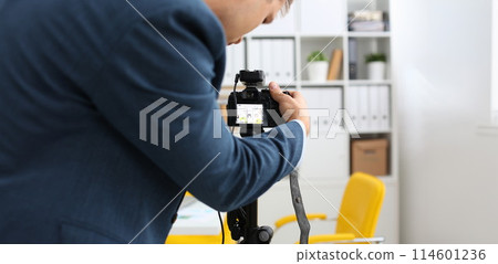 Male arms in suit mount camcorder to tripod Male arms in suit mount camcorder to tripod 114601236