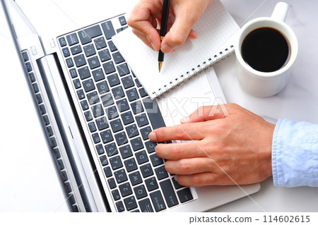 一名辦公室職員在辦公桌前用筆記型電腦一邊喝咖啡一邊工作的圖片 114602615