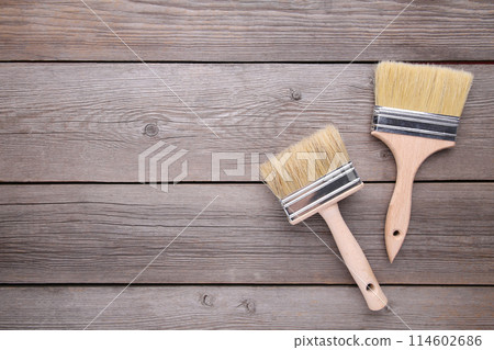 Two paintbrush on a grey wooden background Two paintbrush on a grey wooden background 114602686