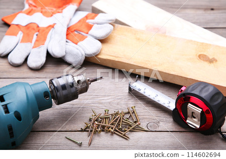 Construction tools on a grey wooden desk. Construction tools on a grey wooden desk. 114602694