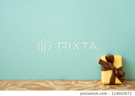 Yellow gift box on wooden table. mint wall background Yellow gift box on wooden table. mint wall background 114603672