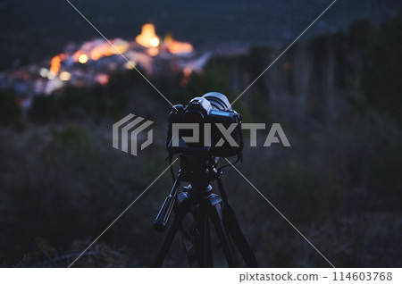 Digital camera placed on tripod, capturing the Andalusian medieval city of Quesada in mountains Sierra de Cazorla at dawn. Blurred mountains on background. Travel photography. World photography Day Digital camera placed on tripod, capturing the Andalusian medieval city of Quesada in mountains Sierra de Cazorla at dawn. Blurred mountains on background. Travel photography. World photography Day 114603768