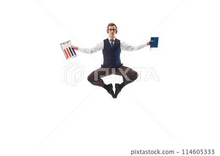 Balance and productivity. Businessman in headphones, in mid-air yoga pose with graphs and documents showing multitasking at work isolated on white background Balance and productivity. Businessman in headphones, in mid-air yoga pose with graphs and documents showing multitasking at work isolated on white background 114605333