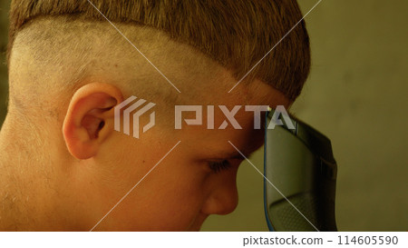 Grandpa cuts a boy's hair with a clipper. Home haircut. 114605590