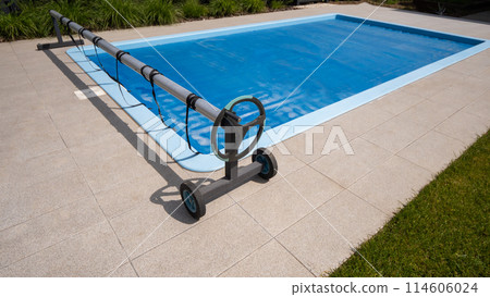 Home outdoor pool covered with film to save chemicals, water and heat preservation 114606024