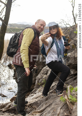 senior couple hiking outdoor, man and woman norwegian walking with sticks landscape senior couple hiking outdoor, man and woman norwegian walking with sticks landscape 114606528