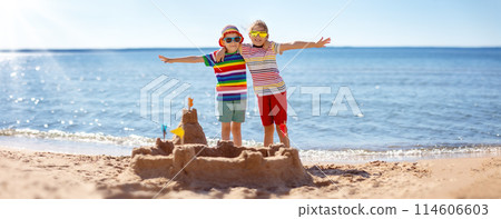 Boy and girl building on the beach sandcastle. 114606603