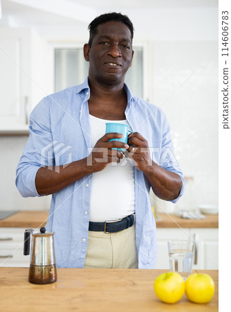 Man drinking and enjoying morning coffee in home kitchen Man drinking and enjoying morning coffee in home kitchen 114606783