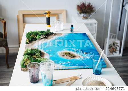 Epoxy Resin Art Depicting a Coastal Landscape on Studio Table 114607771