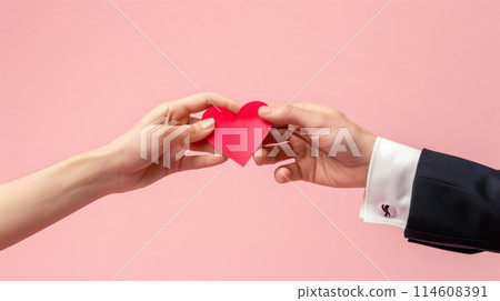 一個男人和一個女人的手拿著一個紅心符號 114608391