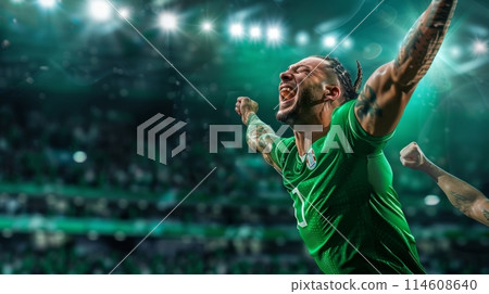 Football player celebrating victory under stadium lights after game 114608640