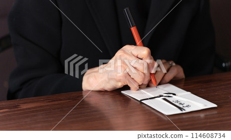 Senior woman in mourning clothes, condolence money 114608734