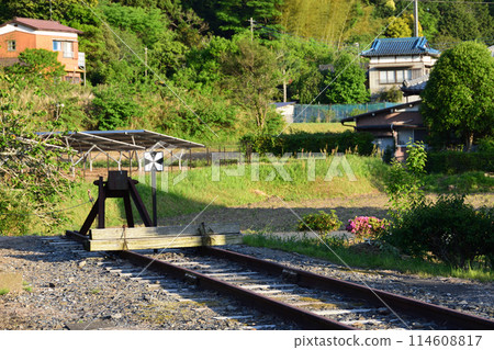 A car stop at the end of Kazusa Kameyama Station bathed in the setting sun 114608817