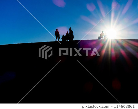 夕陽照耀下，一家人在山上行走的剪影 114608861