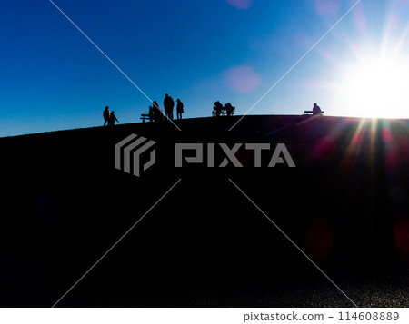 Silhouette of a family walking along a hill illuminated by the setting sun Silhouette of a family walking along a hill illuminated by the setting sun 114608889