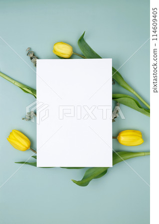 Empty white paper blank, flowers on green background. Wedding branding mock up. Top view. Copy space Empty white paper blank, flowers on green background. Wedding branding mock up. Top view. Copy space 114609405