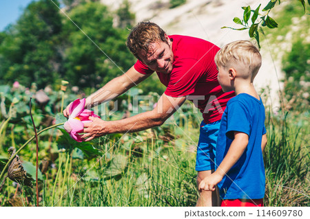 Father son study plants, looking on buds flower bud leaves stamens petals. Natural sciences, family education. Happy childhood parenthood harmony 114609780