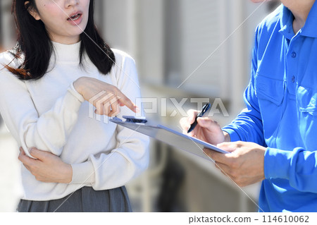 一名女顧客抱怨一名穿著工作服的男子 一名女顧客抱怨一名穿著工作服的男子 114610062