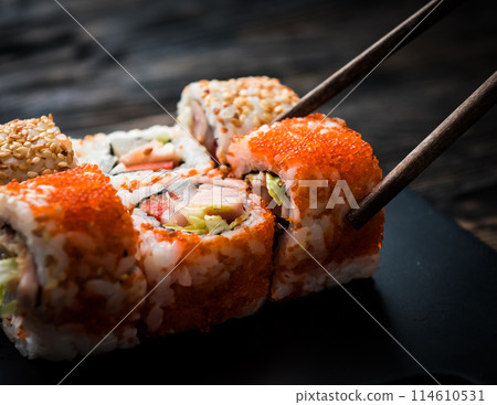 closeup of sushi rolls with chopsticks 114610531