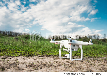 white quadrocopter standing on the ground white quadrocopter standing on the ground 114610570